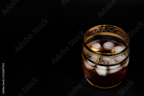 Glass of dark red whiskey, brandy or .bourbon with ice