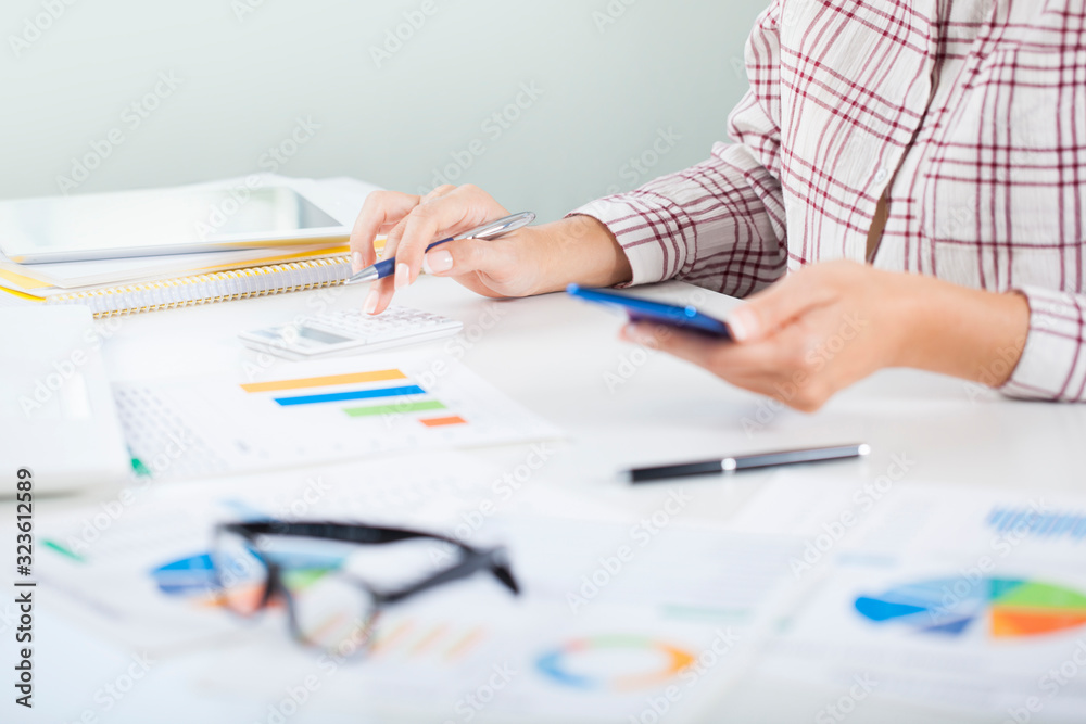 Business woman considers on the calculator in the office Business woman considers on the calculator in the office