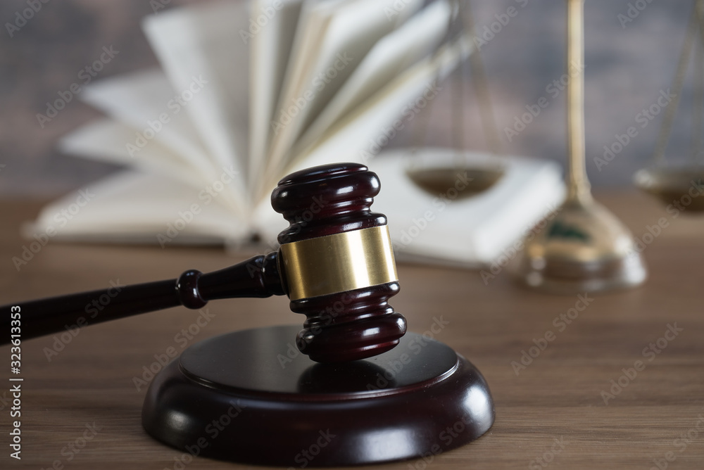 Law and Justice concept. Mallet of the judge, books, scales of justice. Gray stone background, reflections on the floor, place for typography. Courtroom theme.. Wooden rustic background Law and Justice concept. Mallet of the judge, books, scales of justice. Gray stone background, reflections on the floor, place for typography. Courtroom theme.. Wooden rustic background