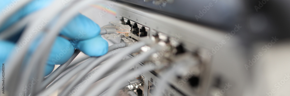 Focus on high-tech ethernet cables in hand of hardworking man wearing ...