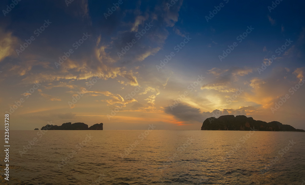 Sea view evening of Phi Phi Leh island (left) and Phi Phi Don island (right) with yellow sun light and cloudy sky background, sunset at Phi Phi Don island, Krabi, southern of Thailand. Sea view evening of Phi Phi Leh island (left) and Phi Phi Don island (right) with yellow sun light and cloudy sky background, sunset at Phi Phi Don island, Krabi, southern of Thailand.