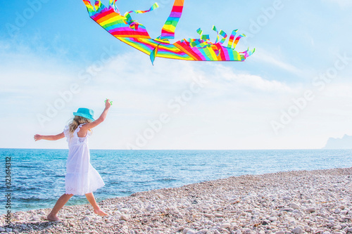 Little girl with kite on the sea