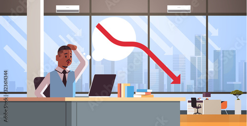 businessman frustrated about falling economic graph arrow fall down financial crisis bankrupt investment risk concept business man sitting at workplace modern office interior horizontal portrait