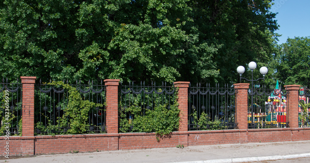 beautiful fence fence made of red brick in the green foliage
