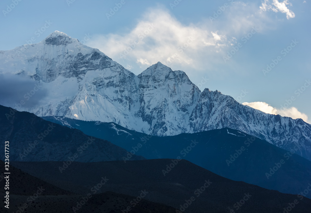 Fototapeta premium The snow covered Nilgiri North mountain seen from the Himalayan village of Kagbeni in Upper Mustang in Nepal. 