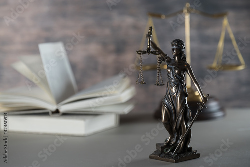 Law and Justice concept. Mallet of the judge, books, scales of justice. Gray stone background, reflections on the floor, place for typography. Courtroom theme.. Wooden rustic background