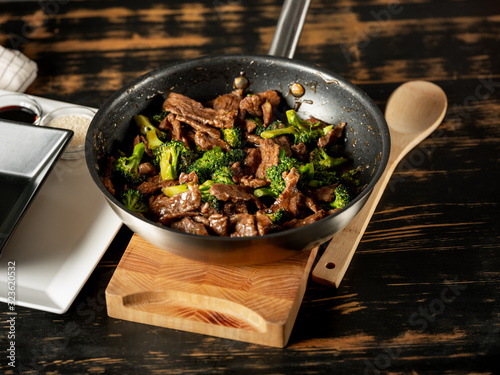 Beef meat and broccoli vegetable cooking in pan close up, selective focus. Traditional food recipe.