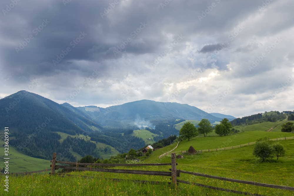 Carpathian slopes with fenced hayfields on a foreground