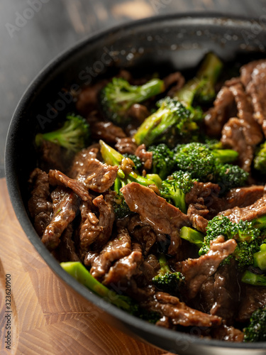 Beef meat and broccoli vegetable cooking in pan close up, selective focus. Traditional food recipe.