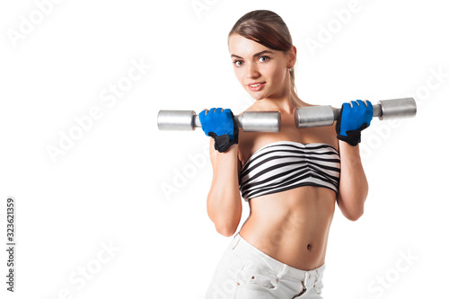 Pretty young caucasian woman fitness instructor doing exercises with studio dumbbells on a white background. Concept of a healthy lifestyle and a beautiful figure. Advertising space