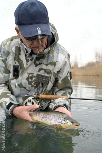 catch of a beautiful brown trout with fly