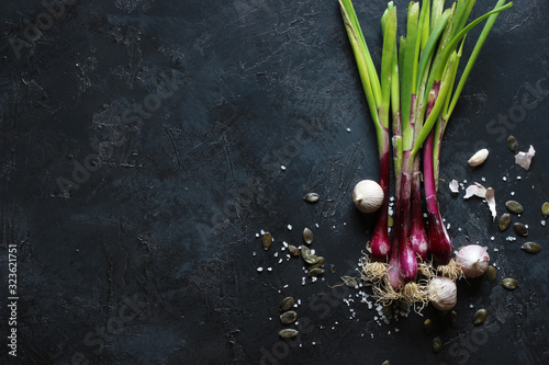 purple spring onions on dark table background