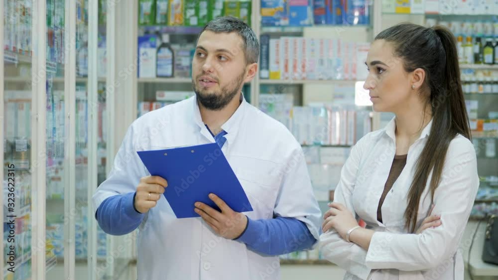Two young promoters makes a reconciliation of drugs in a pharmacy Two young promoters makes a reconciliation of drugs in a pharmacy