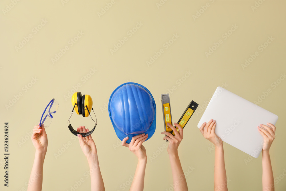 Fototapeta premium Many hands with architect's supplies and laptop on color background