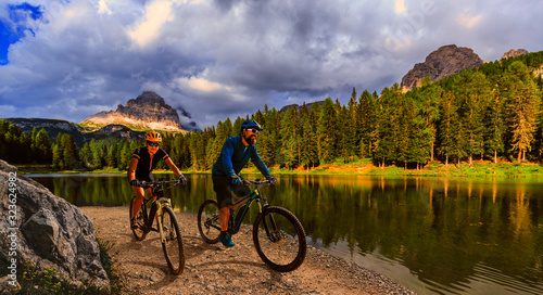 Cycling outdoor adventure in Dolomites. Cycling woman and man on electric mountain bikes in Dolomites landscape. Couple cycling MTB enduro trail track. Outdoor sport activity. © Gorilla