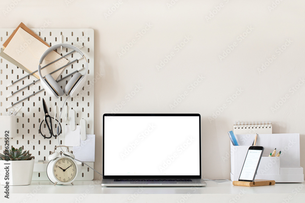 Laptop with blank white screen on office desk interior. Stylish gold workplace mockup table view.