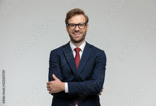 Fototapeta businessman standing with hands crossed and looking at camera happy