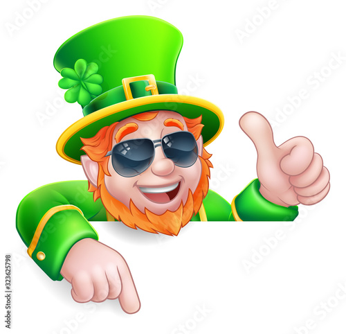 A Leprechaun St Patricks Day cartoon character wearing cool sunglasses. Giving a thumbs up, peeking over a sign and pointing at it