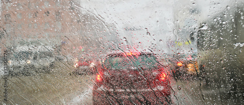 View from the car windscreen during rain and wet snow. Poor visibility while driving around the city. Snowy road.