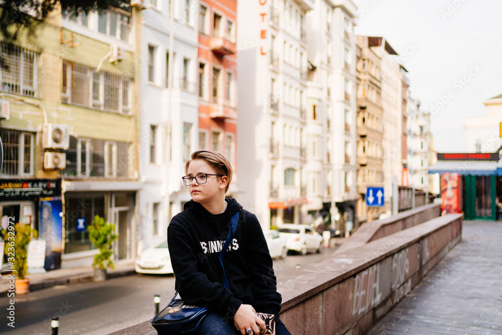 teen with glasses and a black hood sit