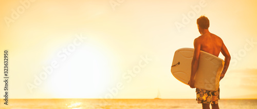 Photography Beach surfer guy looking at ocean going surfing with bodyboard surfboard surf watersport summer travel lifestyle panoramic header for Hawaii sports
