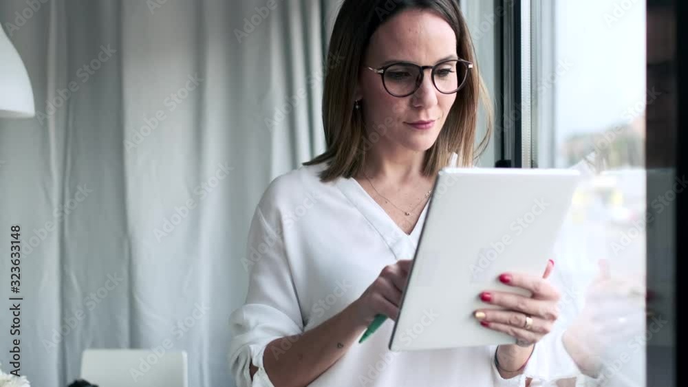 Slow motion shot of businesswoman using tablet at the office Slow motion shot of businesswoman using tablet at the office