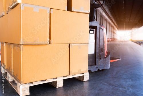 Stack of package boxes on pallet and forklift pallet jack, Interior of warehouse loading shipment goods