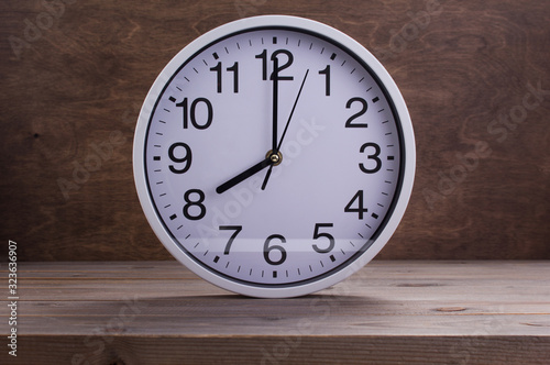 wall clock at wooden table background