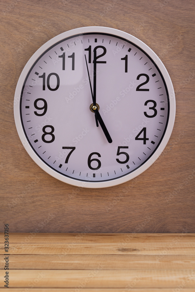 wall clock at wall near wooden table wall clock at wall near wooden table