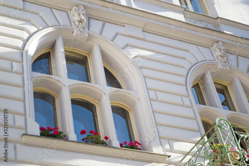 The architecture of the Old Town part of the Prague. Details and elements of architectural decorations on the facades of houses. Windows with flowers close up.