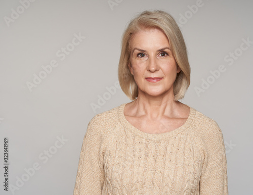 Senior blonde woman isolated on grey