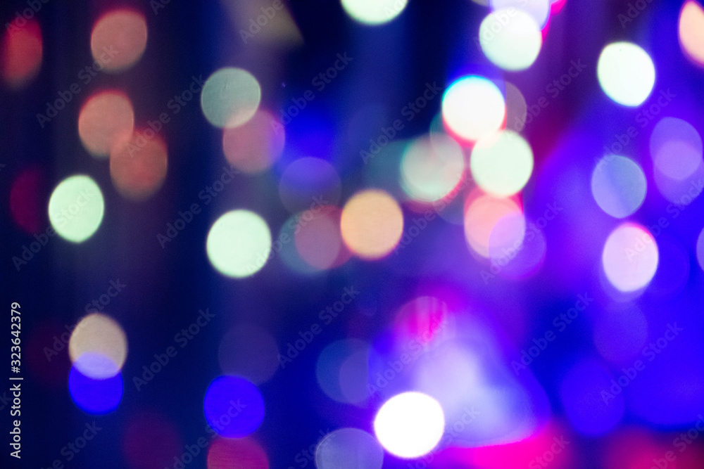 Abstract background with defocused bokeh colorful lights, glowing sparkling lights and reflections