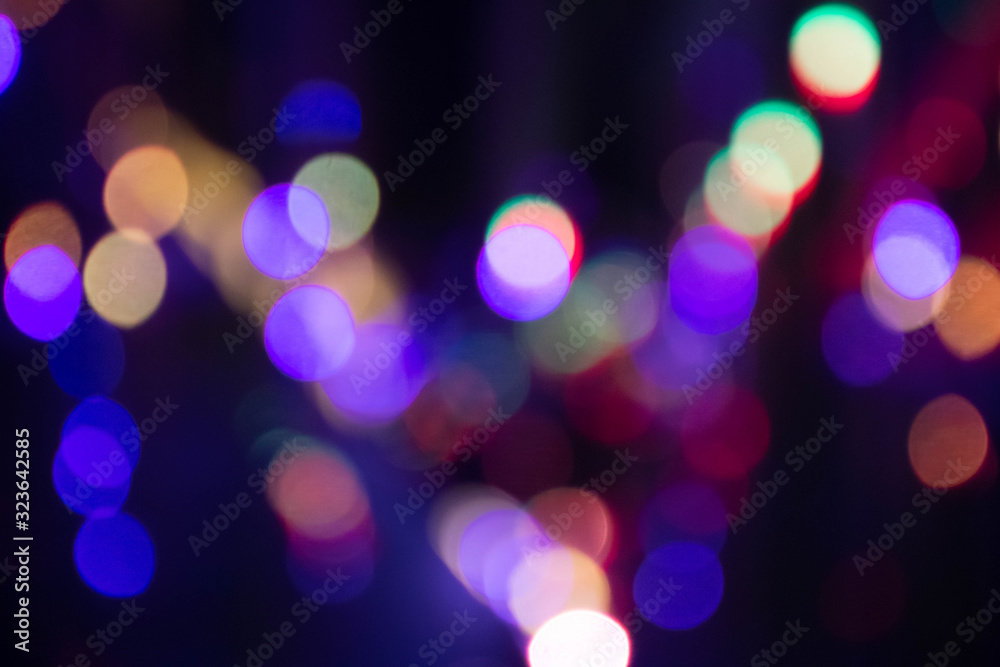 Obraz premium Abstract background with defocused bokeh colorful lights, glowing sparkling lights and reflections