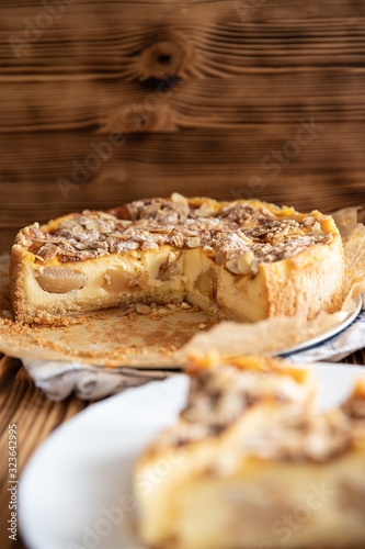 Bratapfelkuchen mit Äpfeln und Mandelblättchen auf dunklen Holzgrund
