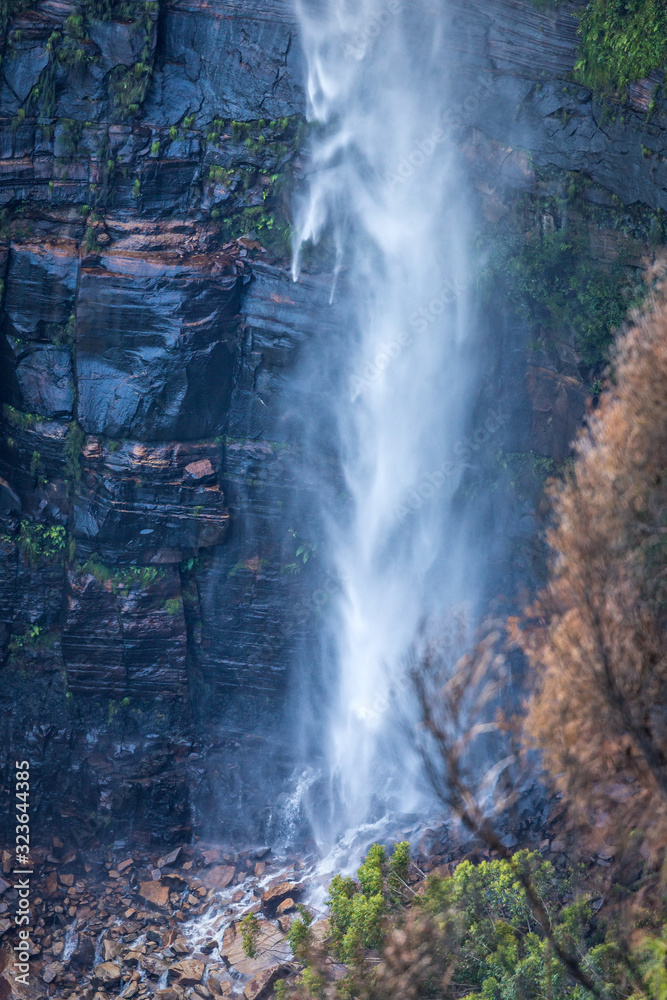 Waterfall tumbling down onto boulders at its base