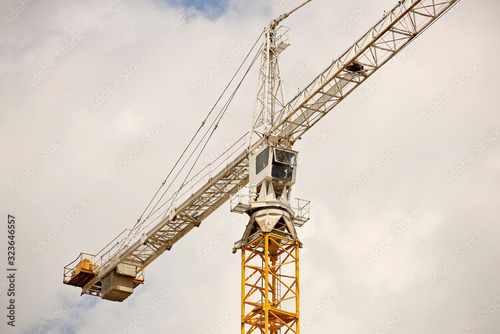 Tower cranes work during the construction of a multi-story building. New apartments for residents and premises for offices. Risky work at height. Lifting heavy building materials. City development Tower cranes work during the construction of a multi-story building. New apartments for residents and premises for offices. Risky work at height. Lifting heavy building materials. City development
