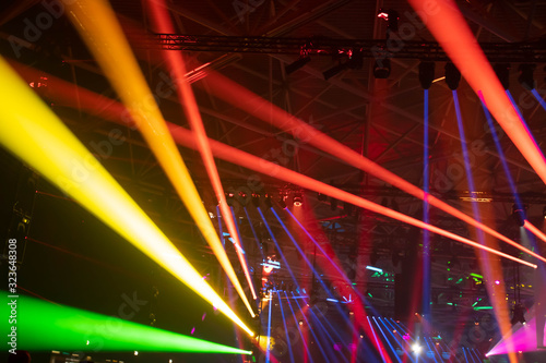 Scene, stage lights with colored spotlights and smoke, laser lights background, rainbow color, defocused