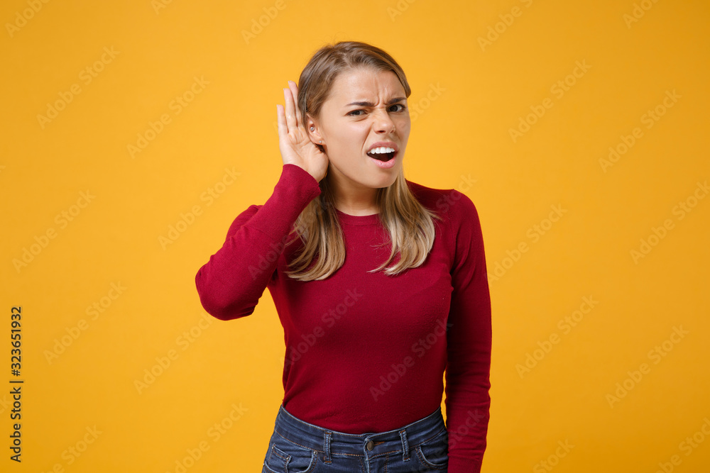 Curious shocked young blonde woman girl in casual clothes posing isolated on yellow orange background studio portrait. People lifestyle concept. Mock up copy space. Try to hear you with hand near ear. Curious shocked young blonde woman girl in casual clothes posing isolated on yellow orange background studio portrait. People lifestyle concept. Mock up copy space. Try to hear you with hand near ear.