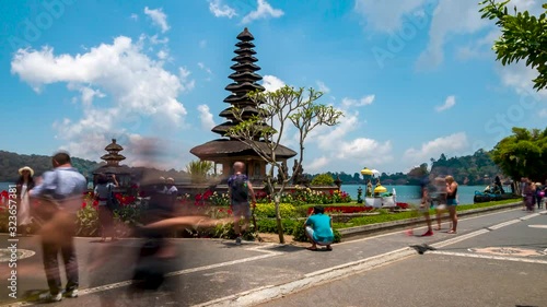 BALI, INDONESIA - OCTOBER 12, 2019: Timelapse of large numbers of tourists posing for photographs at the Ulun Danu Bratan temple in Bali