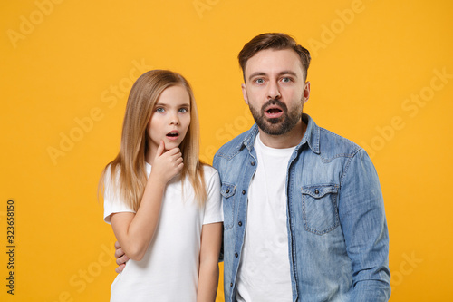Shocked bearded man in casual clothes have fun with child baby girl. Father, little kid daughter isolated on yellow orange background. Love family day parenthood childhood concept. Keeping mouth open.