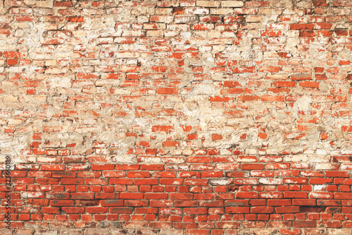 Ancient old abandoned stained damaged red brick wall with gray cement seam. Abstract trendy modern texture background