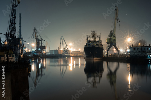 night port on the river with a large ship and cranes