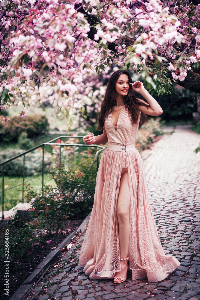 romantic girl stands in a blooming garden