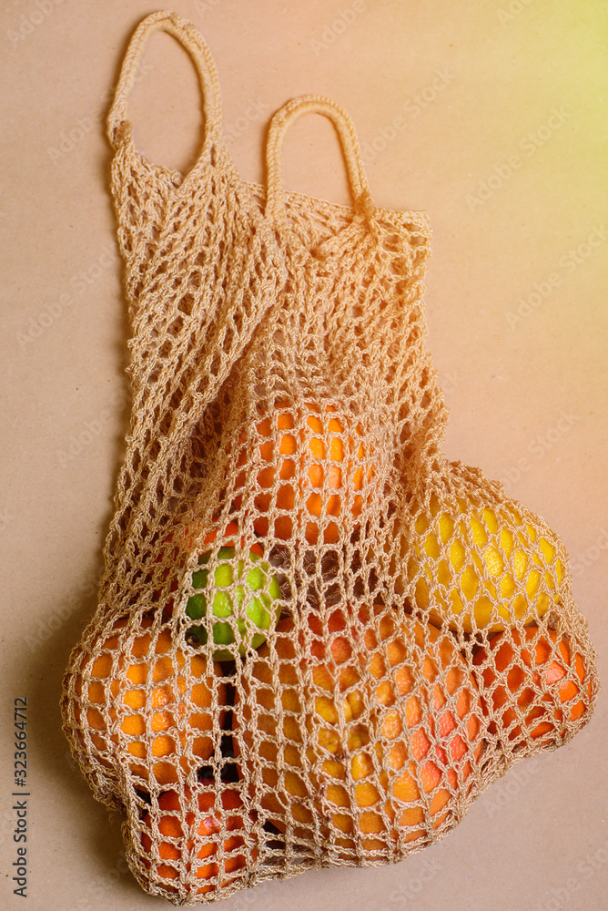 Obraz premium Fresh lemon, oranges, grapefruit and lime in string bag.