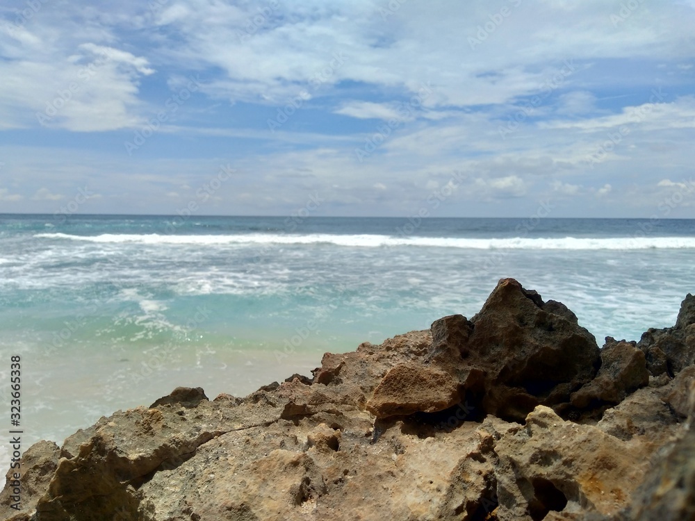 Beach with rocks, waves and blue sky. The beautiful Sanggar beach in Tulung Agung, East Java, Indonesia. Beach with rocks, waves and blue sky. The beautiful Sanggar beach in Tulung Agung, East Java, Indonesia.