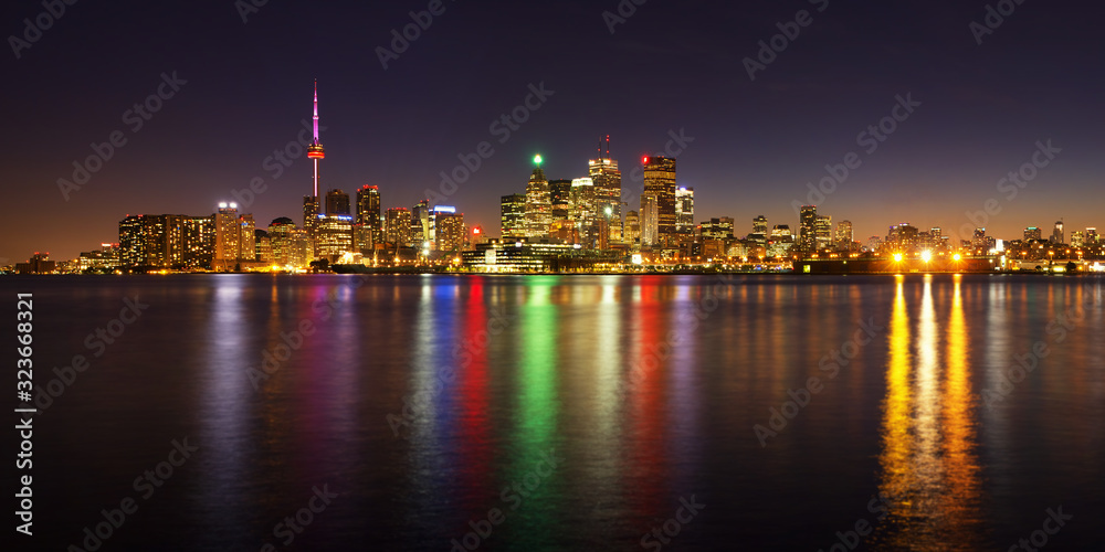 Toronto cityscape panorama at dusk over lake with colorful light Toronto cityscape panorama at dusk over lake with colorful light