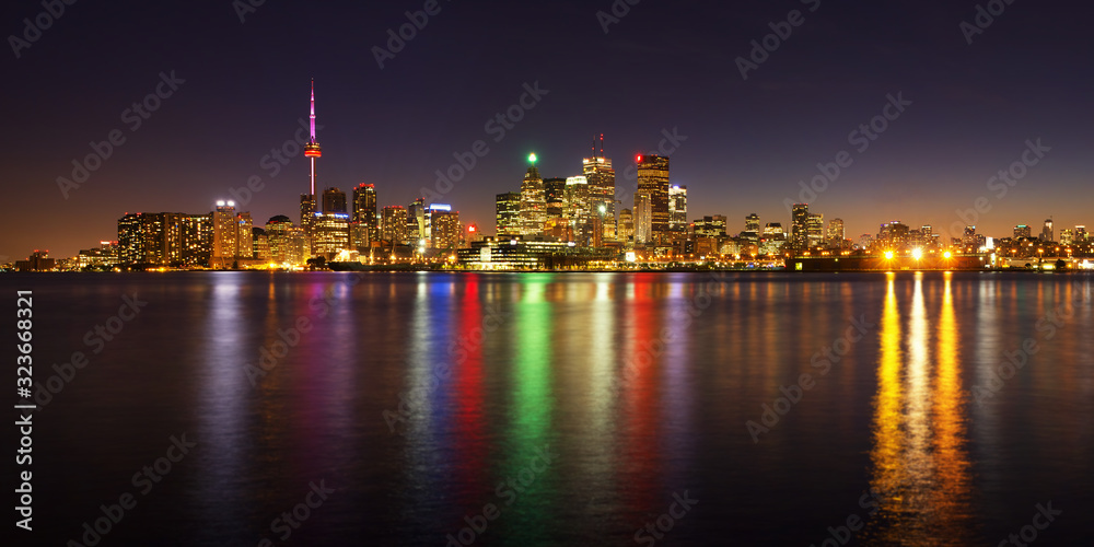 Toronto cityscape panorama at dusk over lake with colorful light