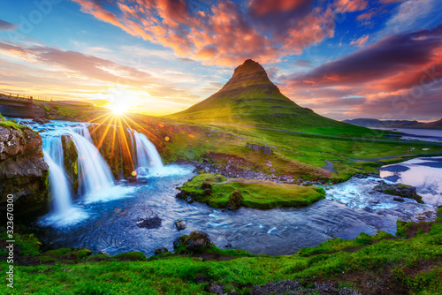 Fotografie, Obraz Gorgeous landscape with rising sun on Kirkjufellsfoss waterfall and Kirkjufell mountain, Iceland, Europe