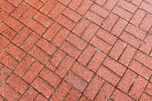 Brown cobble stone walkway get wet cause of rain. Pavement texture.