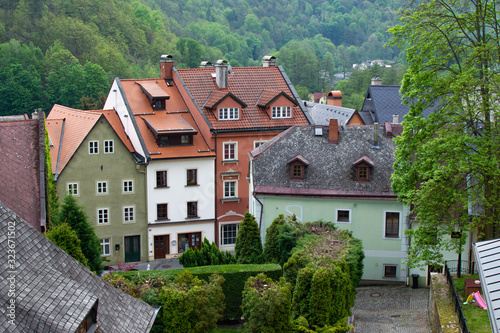 Typical colorful czech houses in Loket  a picturesque town in Czech Republic  with the green trees of the mountain at the background